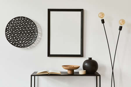 Minimalistic stylish composition of creative room interior design with mock up poster frame, metal shelf, industrial lamp and personal accesories. Black and white concept. Template.の写真素材