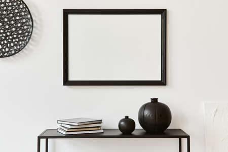 Minimalistic stylish composition of creative room interior design with mock up poster frame, metal shelf and personal accesories. Black and white concept. Template.の写真素材