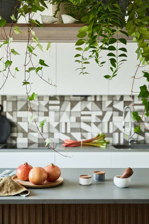 Stylish kitchen interior design with kitchen island. Workspace with kitchen accessories in the...