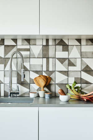 Stylish kitchen interior design in modern apartment with workspace with wooden kitchen accessories. Creative walls. Minimalistic style and plant love concept. Details.の写真素材