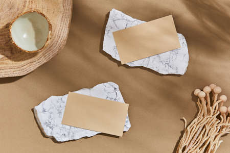 Flat lay of interior design composition with mock up visit cards, rocks, wood, natural materials,...