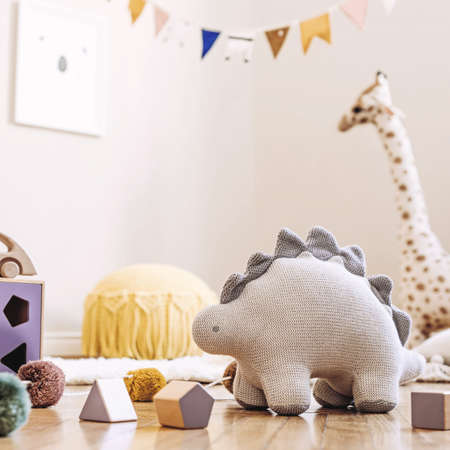 Stylish scandinavian interior of child room with mock up frame, natural toys, hanging decoration, design furniture, plush animals, teddy bears and accessories. Interior design of kid room. Template.の写真素材