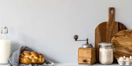 Modern composition on the kitchen interior with vegetables cutting board, food, herbs, kitchen accessories and copy space on the shelf.の写真素材