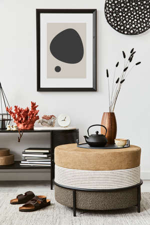 Stylish living room interior composition with mock up poster frame, pouf, console and elegant personal accessories. Copy sapce. Template.の写真素材