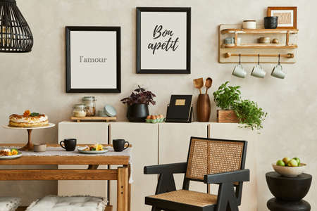 Creative and cozy kitchen interior composition with mock up poster frames, beige commode, plants, chair, family table and elegant accessories. Template.の写真素材