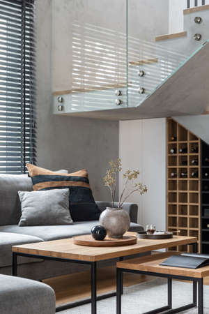 Stylish composition of living room interior with corner gray sofa, green velvet armchair, coffee...