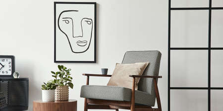 Stylish scandinavian composition of living room with design armchair, black mock up poster frame,...