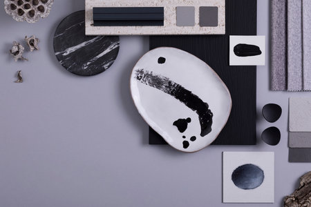 Creative flat lay composition in gray and black color palette with textile and paint samples, panels...