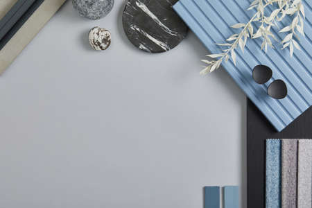 Flat lay composition of stylish architect moodboard with samples of textile, paint, blue wooden lamella panels and tiles. White, black, blue and light gray color palette. Copy space. Template.の写真素材
