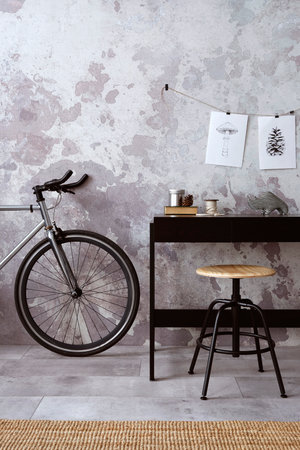 Concrete interior of home office with copy space, black desk, office accessories and plants. Rack with personal accessories. Home decor. Template.の写真素材