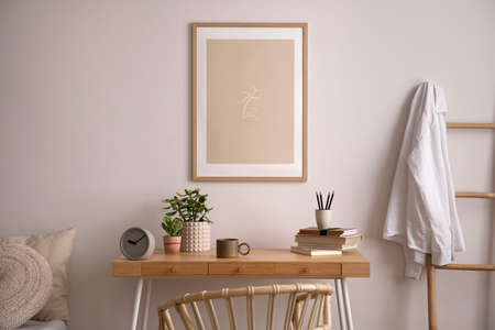 Stylish composition of cozy bedroom with mock up, desk, plants, armchair and wooden coffee table....