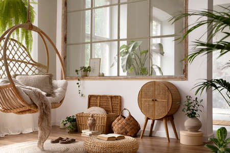 The stylish boho composition with changing swing, window, commode and wooden bench. Beige carpet with brown slippers. White wall. Template.の写真素材