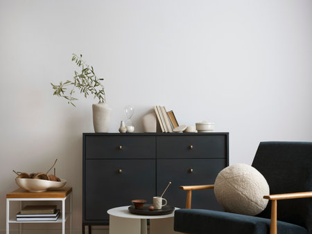Creative composition of living room interior with navy blue commode, velvet armchair, round pillow, coffee table, decoration and personal accessories. Stylish home decor. template.の写真素材