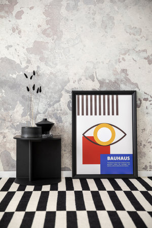 Modern composition of loft living room interior with colorful mock up poster frame, coffee table, vase with dried flowers and patterned carpet. Gray concrete wall. home dÃ©cor. template.の写真素材