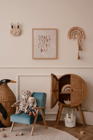 Minimalist composition of kid room interior with mock up poster frame blue armchair, plush toys, wooden blocks, rattan sideboard, beige wall with stucco, braided penguin and personal accessories. home dÃ©cor. template.の写真素材