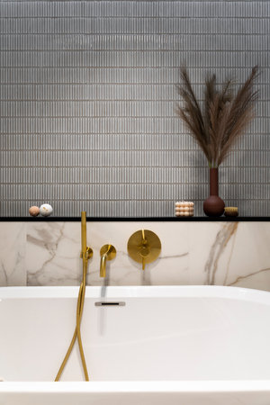 Interior design of elegant bathroom space with gold bathroom faucets, bath, blue and pink tiles, classic white bath, buble candle, brown wase with dried flowers. home dÃ©cor. template.の写真素材