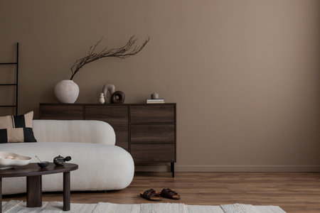Minimalist composition of cozy living room interior with copy space, boucle sofa, wooden sideboard, patterned pillow, stylish coffee table, carpet and personal accessories. Home decor. Template.の写真素材