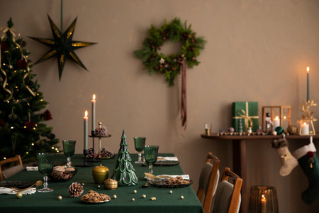 Christmas composition of dining room interior with table with green table cloth, wooden console, christmas tree, wreath, cookies, candle with candlestick and personal accessories. Home decor Templateの写真素材