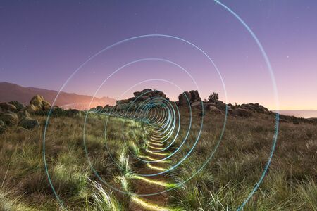 Abstract spiral light painting in a fieldの写真素材