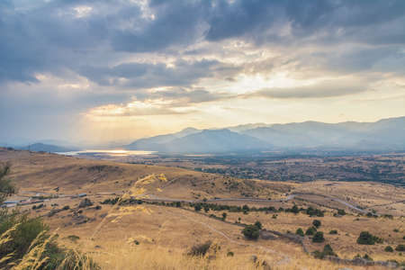 View of a countryside with a spectacular sunset over the lake at backgroundの写真素材