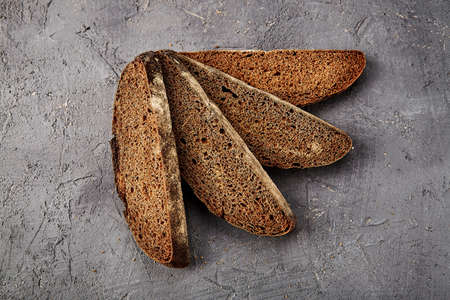 Bakery - gold rustic crusty loaves of bread and buns on gray chalkboard background.の写真素材