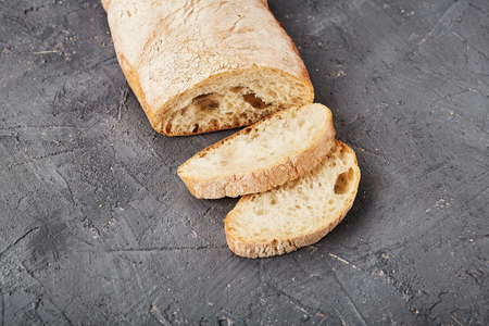 Bakery - gold rustic crusty loaves of bread and buns on gray chalkboard background.