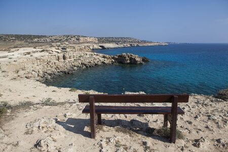 Lonely bench by the blue seaの写真素材