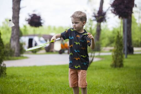 Portrait of happy little boy holding badminton.の写真素材