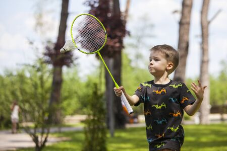 Portrait of happy little boy holding badminton.の写真素材