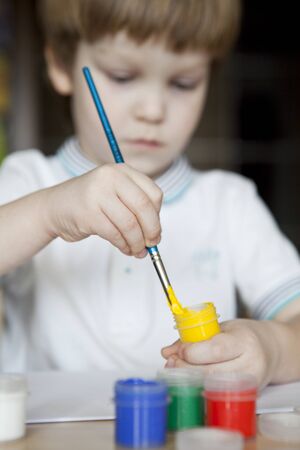 Portrait of a little boy enjoying his paintingの写真素材