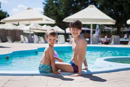 Two brothers near the pool on a summer dayの写真素材