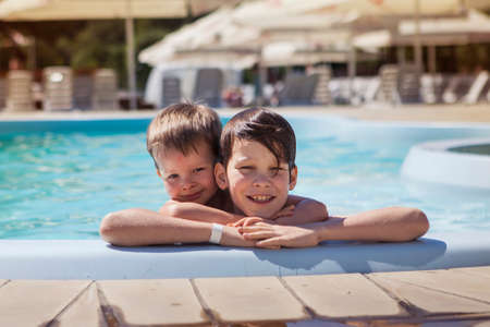 Two brothers near the pool on a summer dayの写真素材