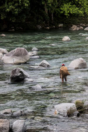 Toa man crossing river after workの写真素材