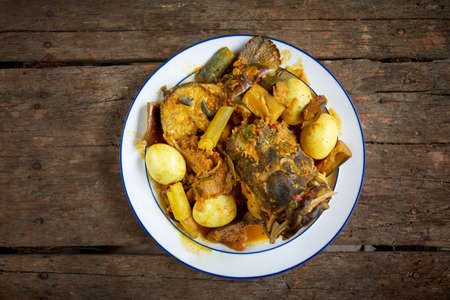 Tasty fish curry cooked in coconut milk on wooden tableの写真素材
