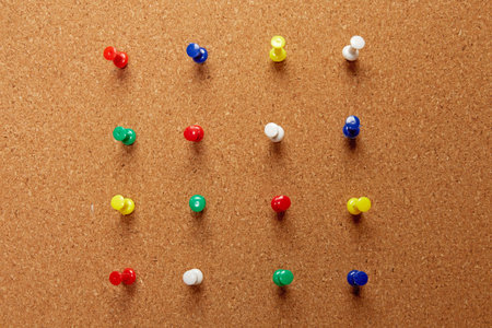 Group of thumbtacks pinned on corkboard