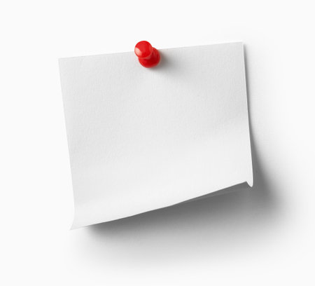 close up of a note paper with a red push pin on white backgroundの写真素材