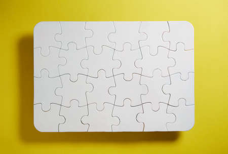 Set of black and white puzzle pieces isolated on yellow background