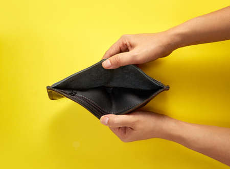 Hand showing a empty wallet on yellow background