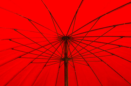 A red beach umbrella blocks out the hot, tropical sun.の写真素材