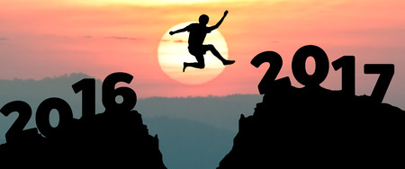 silhouette man jumps to make the word Happy New Year 2017 with sunrise. (New Year 2017 is coming...