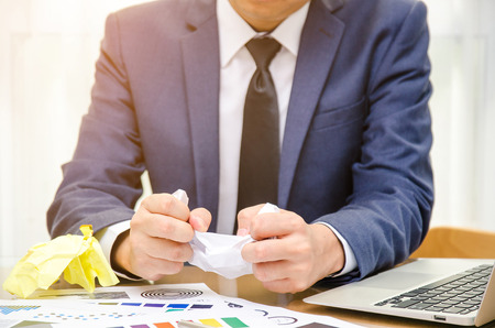Businessman with suit holding crumpled paper ball. failure idea conceptの写真素材