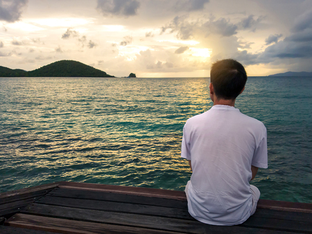 silhouette of thinking man on bench by sunsetの写真素材