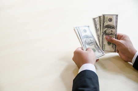 Close Up Business Man Hands Count Hundred Dollar Bills with copy spcae for label textの写真素材