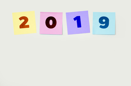 The post is attached to the white wall with has the write 2019 (Happy new year 2019 resolution...