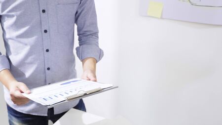 Men in casual wear are holding company earnings data files report. The project owner is analyzing...