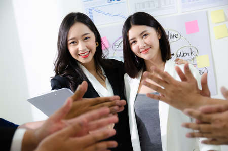 Diverse business people in boardroom, Asian businesswoman promoted reward for good job embraces shoulder by director standing in front of workers clapping hands. Career development success at workの写真素材