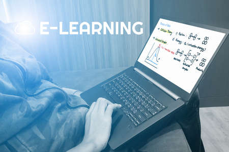 Rear view of young man, entrepreneur, sits at home on couch at coffee table working on laptop with an inscription of Chemistry formula e-learning on screen. Education, e-learning concept.の写真素材