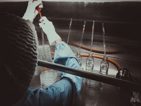 Blurred of scientist doing the microbiology testing in laminar air flow cabinet at the...