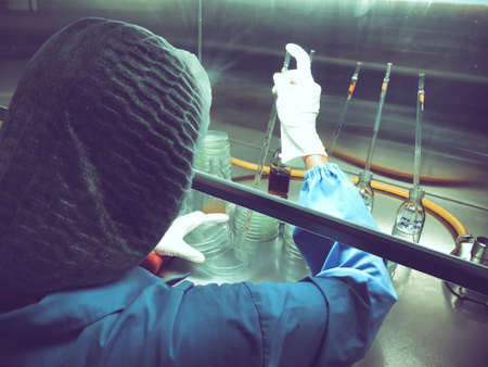 Blurred of scientist doing the microbiology testing in laminar air flow cabinet at the microbiological limit test roomの写真素材