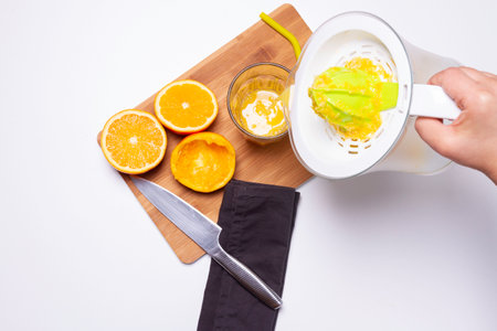 serving orange with a squeezer to the glassの写真素材